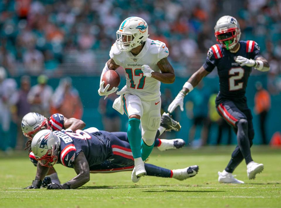 Miami Dolphins wide receiver Jaylen Waddle (17) runs away from Patriots defenders on his way to scoring a touchdown during second quarter action of their game against New England Patriots during NFL game Sept 11, 2022, at Hard Rock Stadium in Miami Gardens.