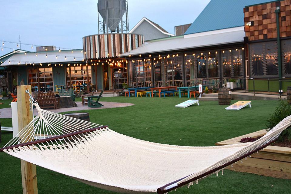 The backyard of Crooked Hammock in Middletown contains hammocks and cornhole games. 