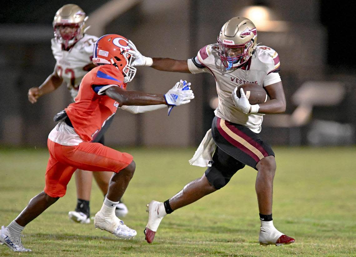 DONN RODENROTH,Macon, Georgia, 08/19/2022: Westside High running back Kadiphius Iverson shoves off a Central defender and picks up a first down in action Friday night at Henderson Stadium. Donn Rodenroth/For The Telegraph