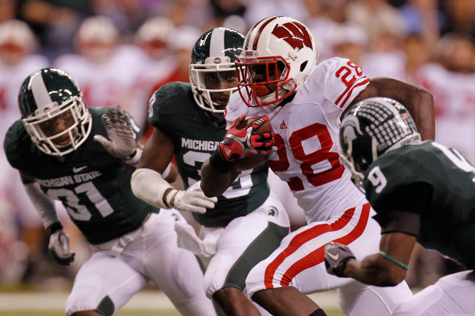 INDIANAPOLIS, IN - DECEMBER 03: Montee Ball #28 of the Wisconsin Badgers scores his second 6-yard rushing touchdown in the first quarter against Isaiah Lewis #9 of the Michigan State Spartans during the Big 10 Conference Championship Game at Lucas Oil Stadium on December 3, 2011 in Indianapolis, Indiana. (Photo by Gregory Shamus/Getty Images)