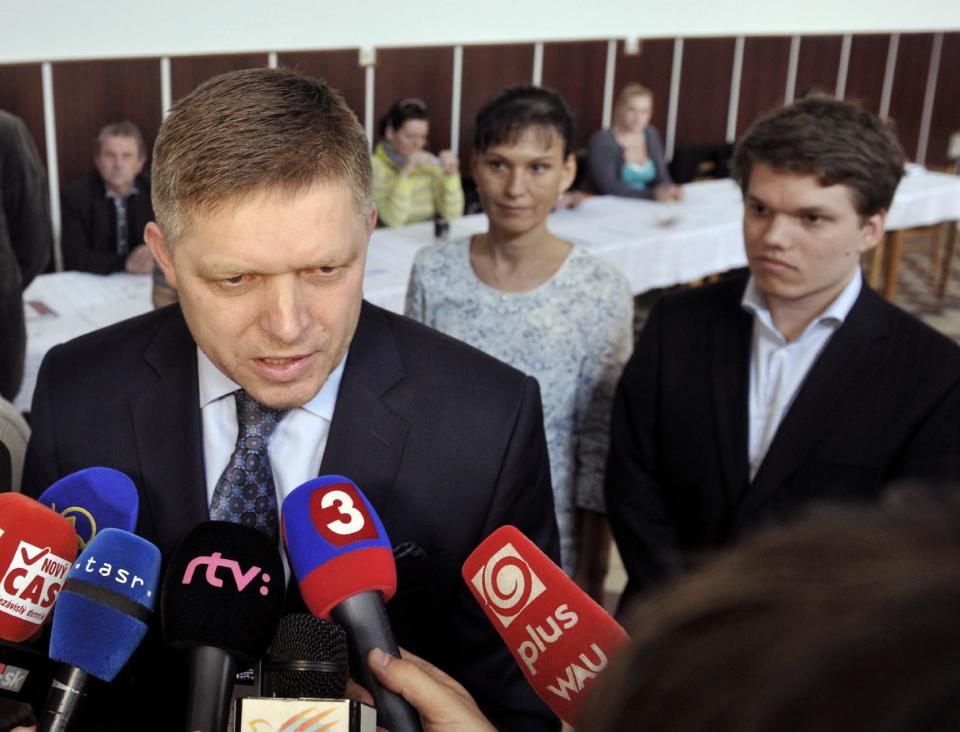 Slovak Prime Minister and presidential candidate Robert Fico, left, speaks to journalists as his wife Svetlana, center, and his son Michal, right, look on after casting their ballots in the second round of the presidential elections in Velke Dvorany, West Slovakia, Saturday, March 29, 2014. (AP Photos,CTK/Jan Koller) SLOVAKIA OUT