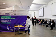 FILE - In this April 6, 2021, file photo, people wait to be vaccinated against COVID-19 at a vaccination center set up at the Stade de France stadium in Saint-Denis, outside Paris. The European Union has ramped up its coronavirus vaccination efforts, even as infections remain doggedly high. (Thomas Samson/Pool Photo via AP, File)