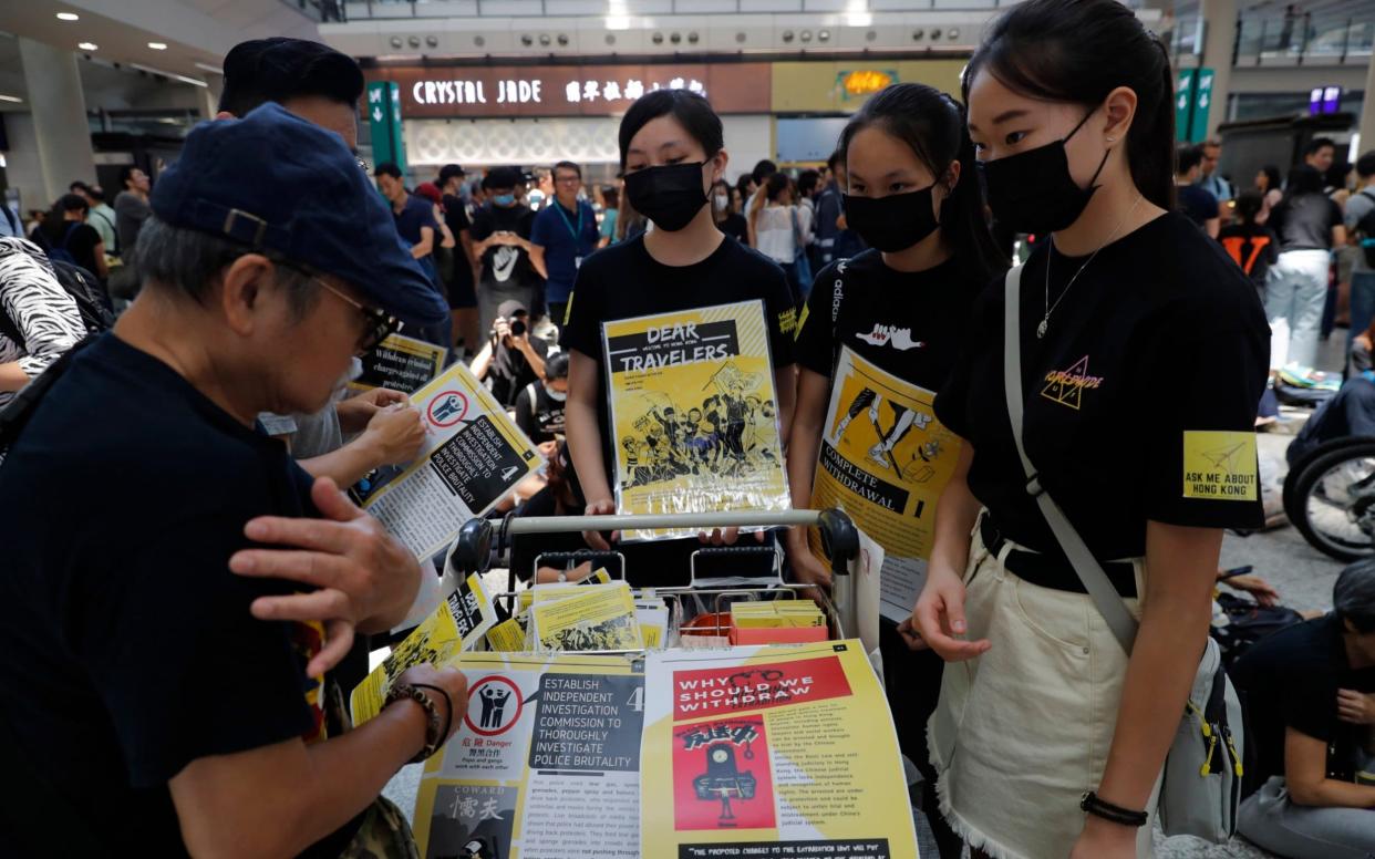 Protesters promote their cause at the airport In Hong Kong on Friday - AP