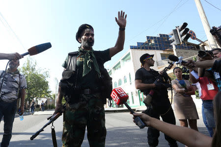 An armed man speaks to media inside the Erebuni police station seized by "Sasna Tsrer" movement members in Yerevan, Armenia, July 23, 2016. REUTERS/Vahram Baghdasaryan/Photolure