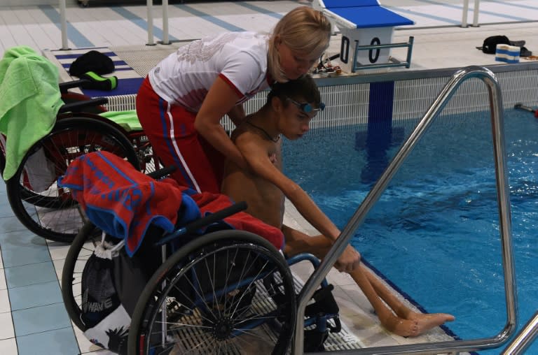 Coach Olesya Alexandrova helps paralympic swimmer Alexander Makarov after a training session in the town of Ruza on August 18, 2016