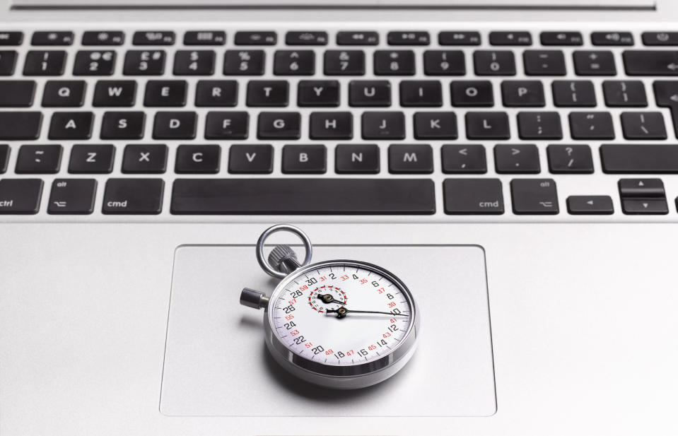 Close up of a stopwatch resting on a laptop's trackpad.