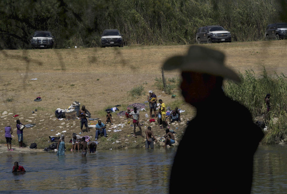 FILE - Migrants, many from Haiti, wade across the Rio Grande from Del Rio, Texas, to return to Ciudad Acuna, some to avoid possible deportation from the U.S. and others to get supplies on Sept. 22, 2021. In September, about 15,000 mostly Haitian migrants camped in the small Texas border town of Del Rio. (AP Photo/Fernando Llano, File)