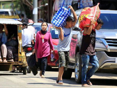 Residents who stayed at evacuation centers, due to the assault of government troops against pro-Islamic State militant groups, carry their belongings affter they were allowed to return to their homes in Basak, Malutlut district in Marawi city, southern Philippines October 29, 2017. REUTERS/Romeo Ranoco