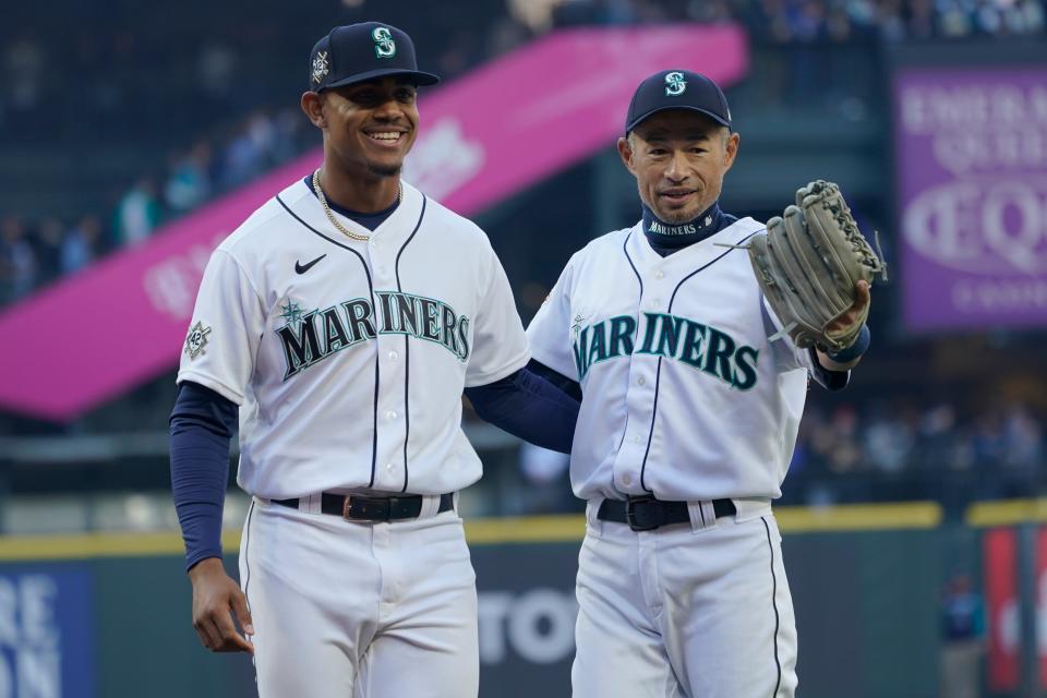 Former Seattle Mariners outfielder Ichiro Suzuki, right, poses for a photo with Mariners outfielder Julio Rodriguez after Suzuki threw out the first pitch to Rodriguez before the team's game against the Houston Astros on April 15, 2022, in Seattle.