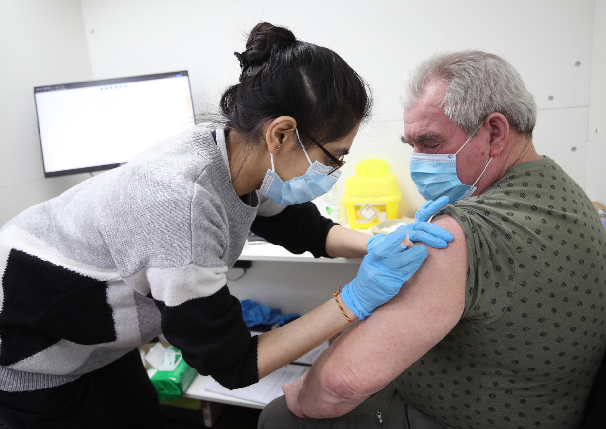 Pooja Patel vaccinates Stanley Piotrowski, 72, on Thursday, as a Tory lockdown sceptic called for all restrictions to be dropped as soon as the top nine priority groups of people receive a jab. (PA)