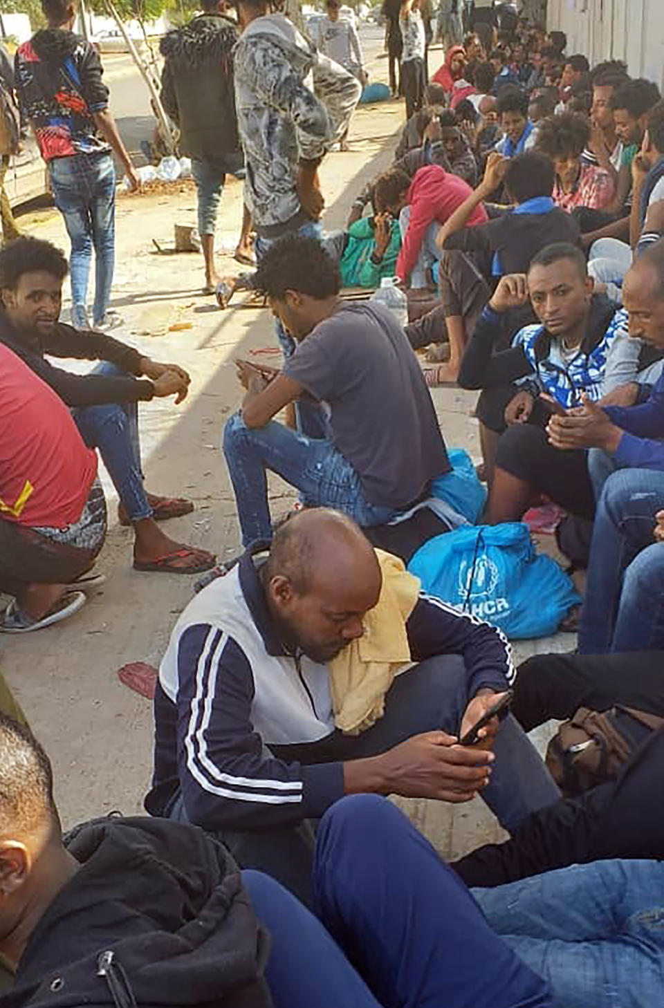 Hundreds of migrants who fled a detention center in coastal Libya crowd around a U.N. facility in Tripoli, Libya, Wednesday, Oct. 30, 2019. Around 450 people left Abu Salim detention center late Tuesday. One of the migrants, as well as activists, say they were forced to beg for money from families to pay police to buy them food. Those who couldn't pay went hungry. (AP Photo)