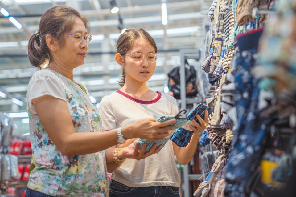 Asian family mother and teenage girl enjoy shopping in a store, illustrating a story on Singapore baby boomers and local businesses. 