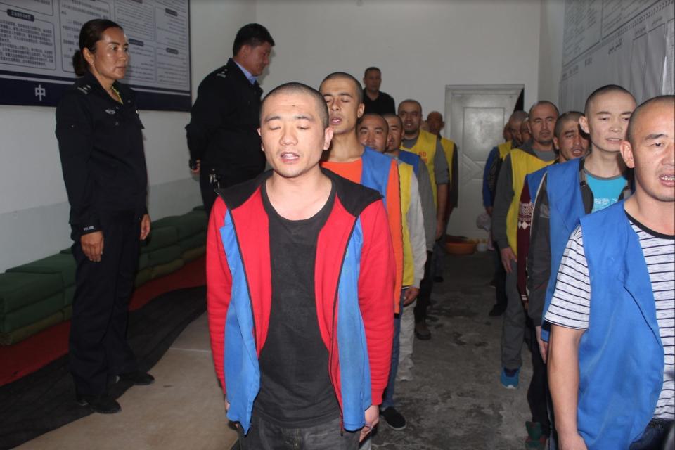 Detainees stand at attention for security personnel inside Tekes Detention Center.