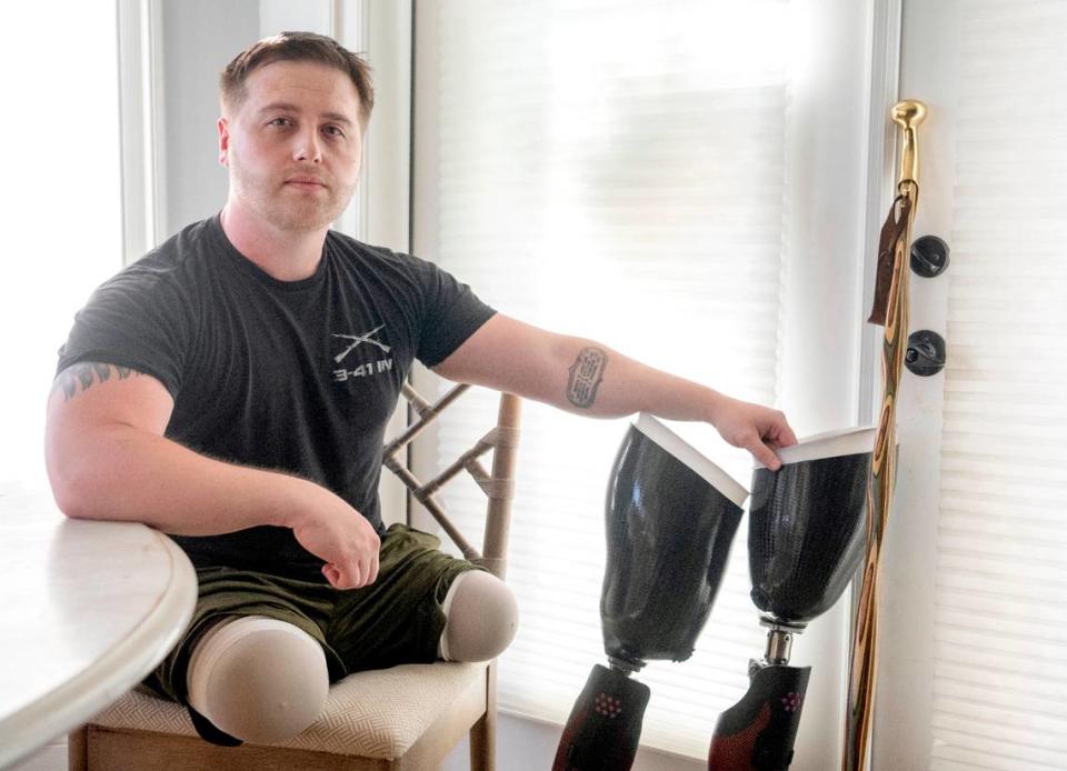 Adam Hartswick has a tattoo on his forearm of his four fellow Army soldiers that were killed on May 14, 2013 in Kandahar, Afghanistan, the same day he lost both of his legs. Hartswick sits in the kitchen the home he shares with wife Sara on Thursday, May 11, 2023.