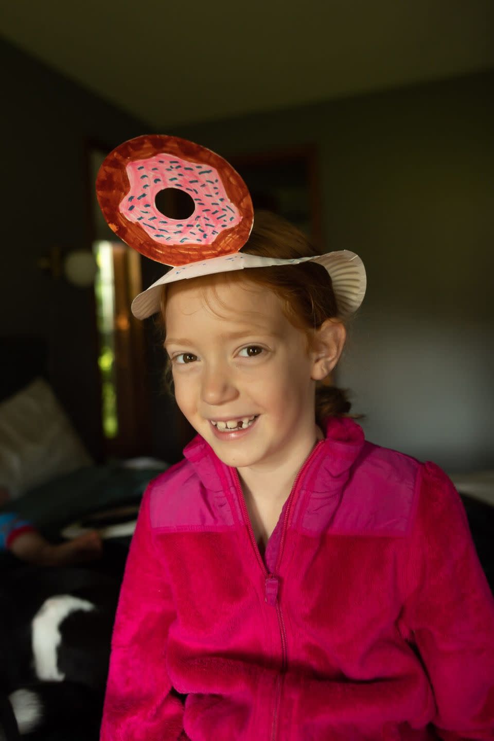 crafts for kids, girl smiling while wearing a paper plate donut