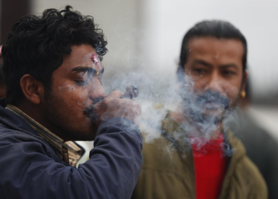 A Nepalese smokes marijuana during Shivaratri festival at the premises of Pashupatinath temple in Kathmandu, Nepal, Friday, Feb. 21, 2020. Hindu holy men were joined by devotees and the public Friday at a revered temple in Kathmandu where they lit up marijuana cigarettes during an annual festival despite prohibition and warning by authorities. Hindu holy men were joined by devotees and the public Friday at a revered temple in Kathmandu where they lit up marijuana cigarettes during an annual festival despite prohibition and warning by authorities. “There is a ban on smoking marijuana but at the same time it is centuries-old tradition which we have to respect,”said police officer Suman Khadka adding there was no arrests made Friday. (AP Photo/Niranjan Shrestha)