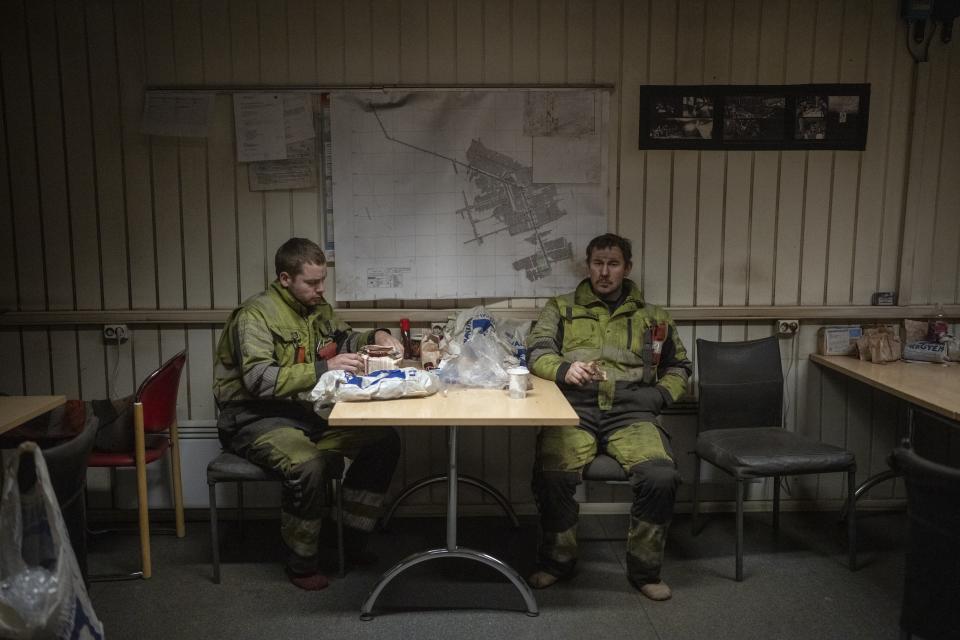 Coal miners rest during a shift in the break room of the Gruve 7 coal mine in Adventdalen, Norway, Monday, Jan. 9, 2023. The mine is scheduled to be shut down in two years, cutting carbon dioxide emissions in this fragile, rapidly changing environment, but also erasing the identity of a century-old mining community that fills many with deep pride even as the primary activities shift to science and tourism. (AP Photo/Daniel Cole)