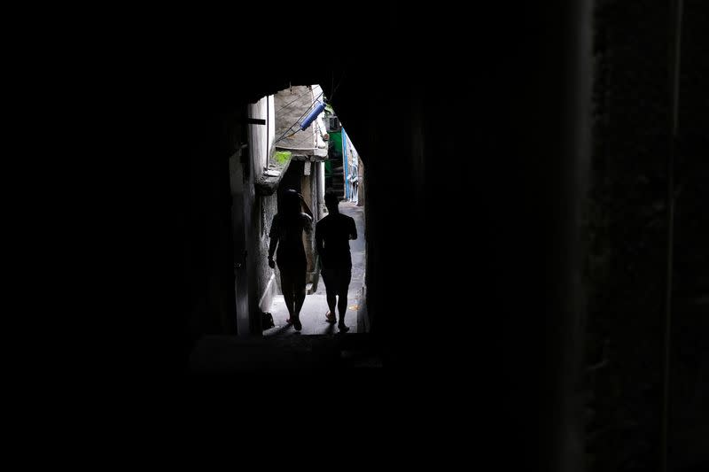 A couple walks through an alley in the Alemao slums complex during the coronavirus disease (COVID-19) outbreak in Rio de Janeiro