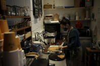 Paulina Filippou serves Spanakopita, the Greek word for spinach pie, in her 'Isle of Olive' Natural Greek Products store and delicatessen, which can stay open for takeaway food and drink and online orders during England's second coronavirus lockdown, on Ada Street, off Broadway Market in Hackney, east London, Tuesday, Nov. 17, 2020. Small businesses all over the world are struggling to cope as the coronavirus forces changes in consumer habits, but the U.K. also faces uncertainty of the Brexit split from Europe. (AP Photo/Matt Dunham)