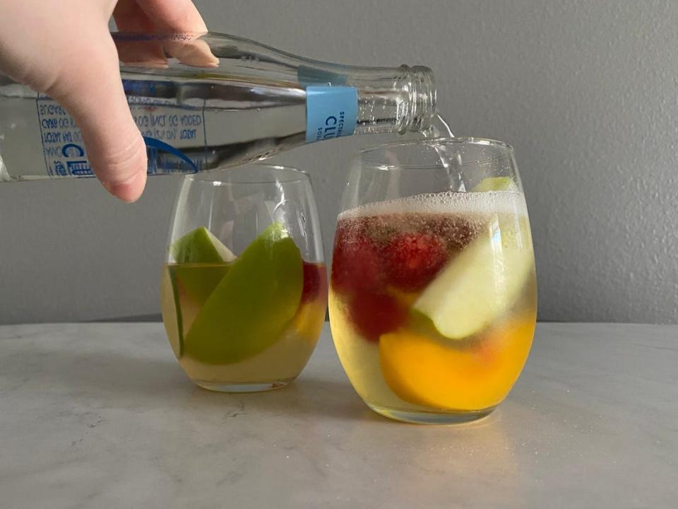 White sangria with apples in a round wine glass.