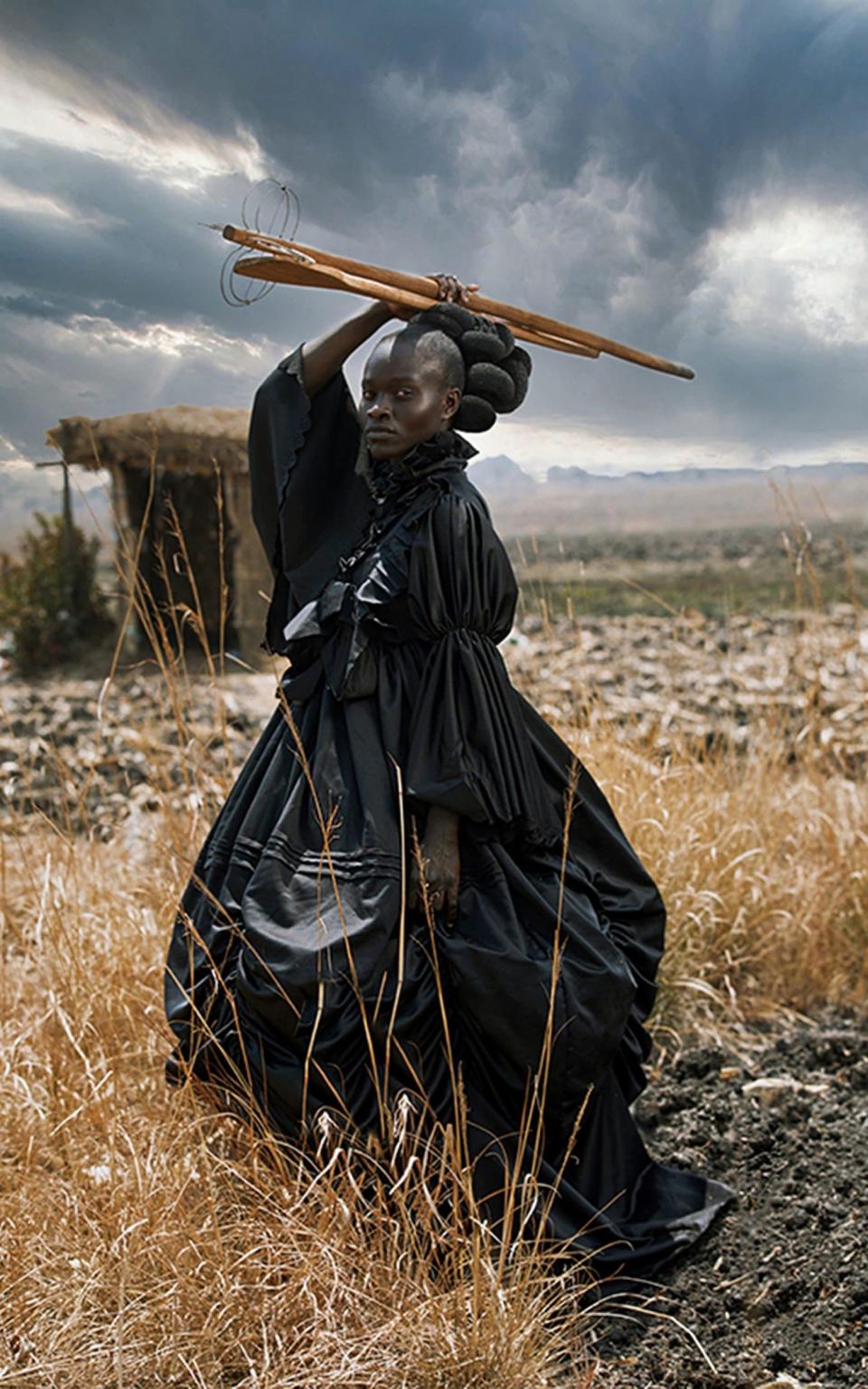 a young black woman dressed in a Victorian dress and holding traditional Shona cooking utensils. The image probes at stereotypical contextualising of the black female body and offers an alternative visual language through which a multifaceted African identity is presented. - Tamary Kudita/Sony World Photography Awards