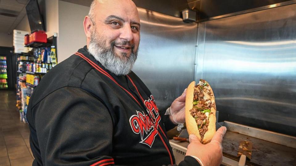 Wilson Tadros, who owns the Willy’s Phillys local Philly cheesesteak sandwich company, holds up one of his foot-long Willy’s Way originals Philly cheesesteak sandwiches at his new location in the 76 gas station at Herndon and and Van Buren Avenue near the Marketplace at El Paseo in northwest Fresno on Friday, May 31, 2023.
