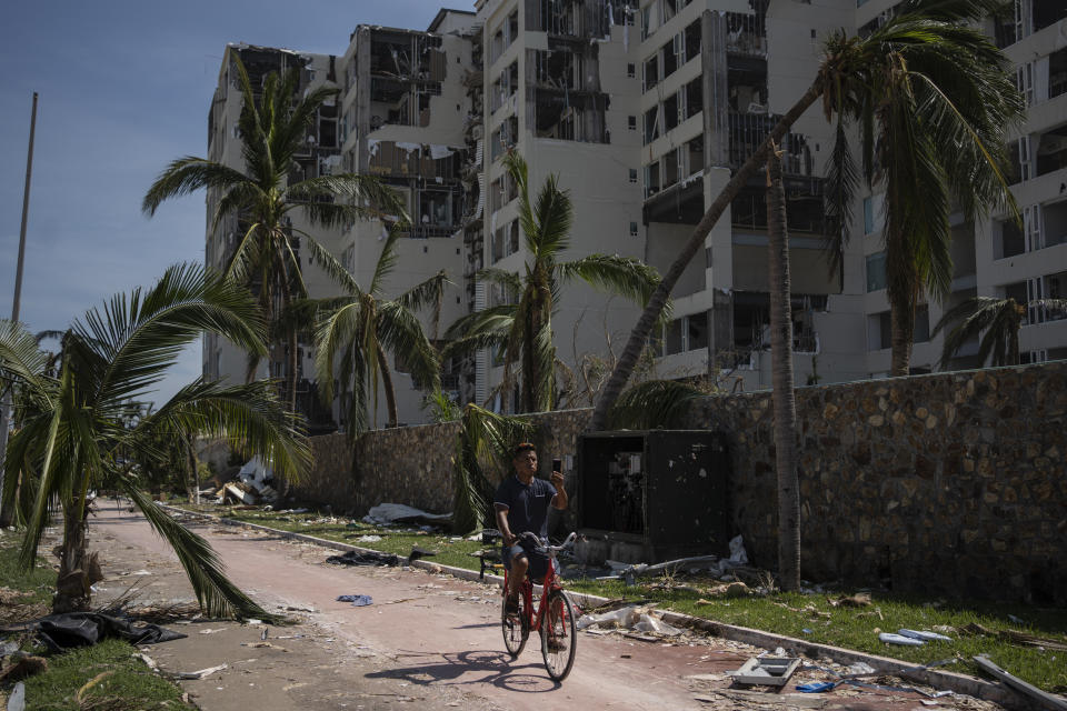 Un hombre pasa en bicicleta por una zona dañada por el huracán Otis, el domingo 29 de octubre de 2023, en Acapulco, México. (AP Foto/Félix Márquez)