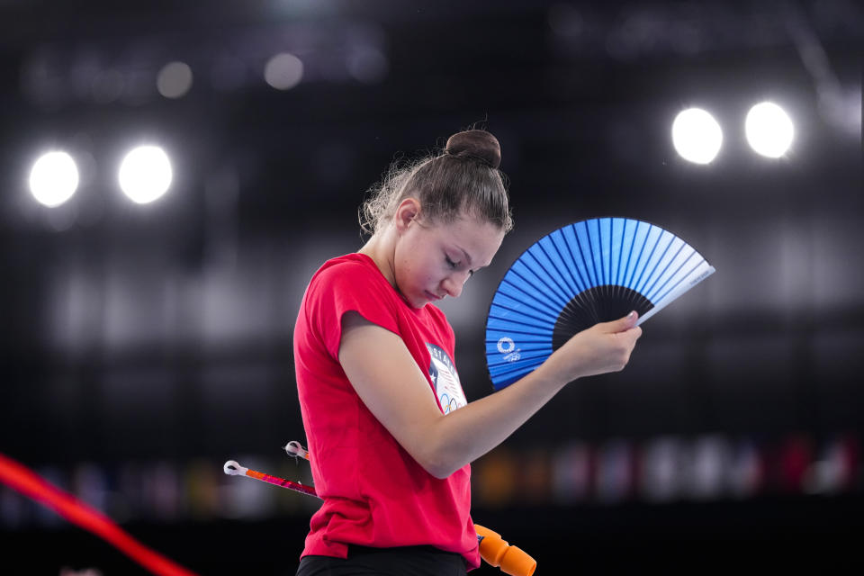 Evita Griskenas from the United States uses a hand fan during a break of her individual rhythmic gymnastics training session at the 2020 Summer Olympics, Thursday, Aug. 5, 2021, in Tokyo, Japan. (AP Photo/Markus Schreiber)