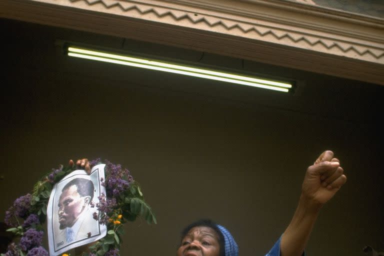 Dos meses después del asesinato de Biko, Winnie Kgware, presidenta del South African Black People's Congress, levanta una fotografía del activista sudafricano