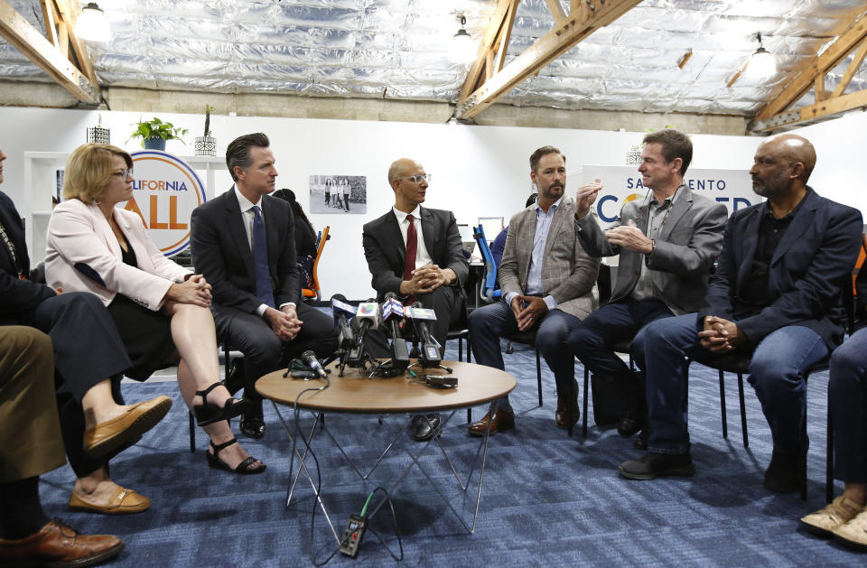 FILE - In this May 14, 2019, file photo, Jim Holifield, second from right, who is semi-retired and runs his own part-time consulting firm, describes the problems of getting health insurance to California Gov. Gavin Newsom, second from left, during a discussion about health care with small business owners, in Sacramento, Calif. The California Legislature approved a bill, Monday, June 24, 2019, that taxes people who refuse to buy health insurance and uses the money to help small business owners and others pay for health insurance. (AP Photo/Rich Pedroncelli, File)