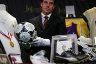 Kendall Capps holds a soccer ball autographed by late soccer star Diego Armando Maradona ahead of the upcoming "Sports: Legends" auction in Culver City