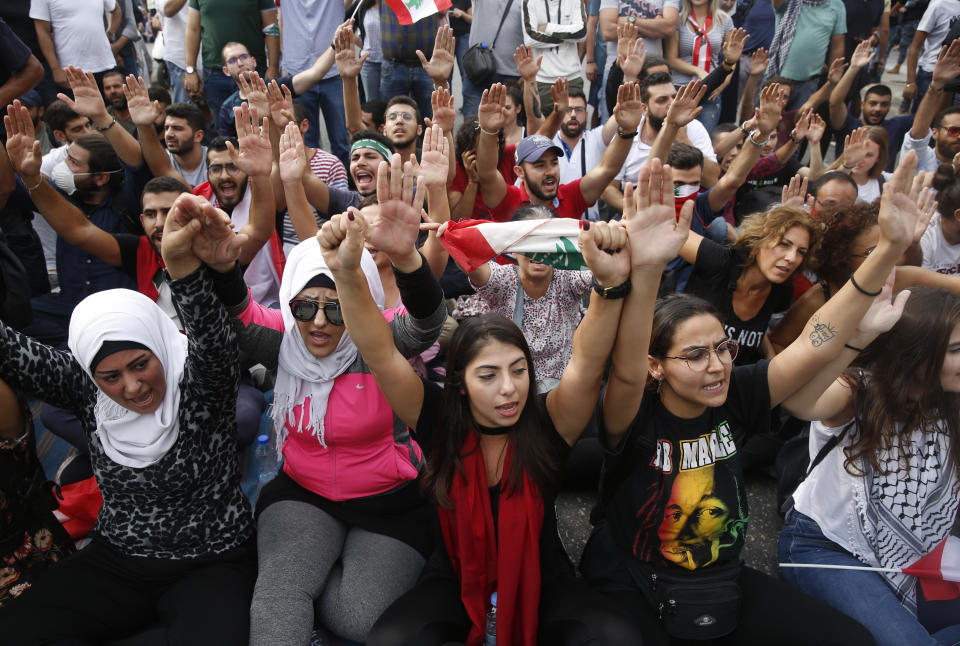 Anti-government protesters shout slogans as they block a main highway, in Beirut, Lebanon, Saturday, Oct. 26, 2019. Lebanese security forces pushed and dragged away protesters who refused to move from roadblocks in central Beirut on Saturday, to reopen roads closed during a campaign of civil disobedience. (AP Photo/Hussein Malla)
