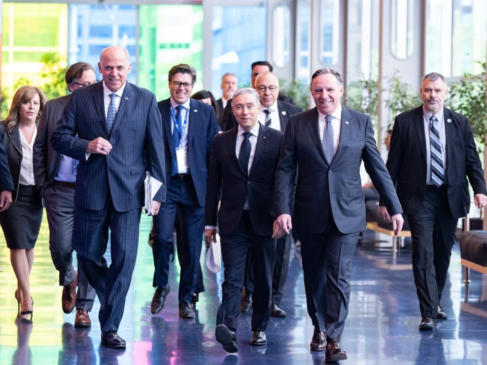 Quebec Premier Francois Legault, right, arrives to make an announcement at the International Aerospace Innovation Forum accompanied by Minister of Innovation, Science and Industry Francois-Philippe Champagne, centre and Quebec Economy and Innovation Minister Pierre Fitzgibbon, left, in Montreal, Tuesday, May 21, 2024.THE CANADIAN PRESS/Christinne Muschi