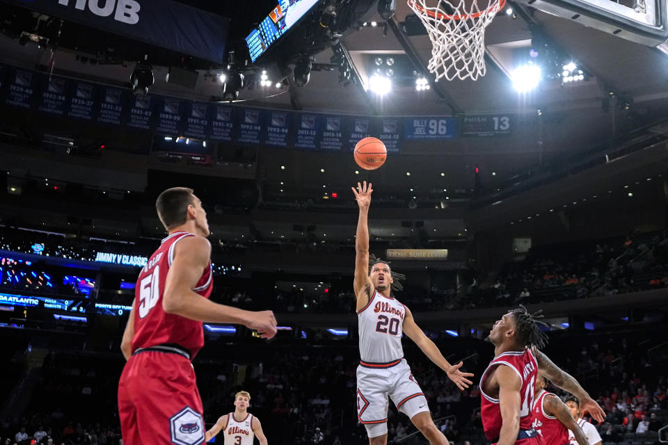 Illinois' Ty Rodgers shoots between Florida Atlantic's Vladislav Goldin, left, and Alijah Martin (15) during the first half of an NCAA college basketball game in New York, Tuesday, Dec. 5, 2023. (AP Photo/Peter K. Afriyie)