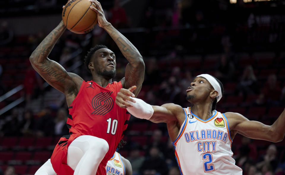 Portland Trail Blazers forward Nassir Little, left, looks to shoot over Oklahoma City Thunder guard Shai Gilgeous-Alexander during the second half of an NBA basketball game in Portland, Ore., Sunday, March 26, 2023. (AP Photo/Craig Mitchelldyer)