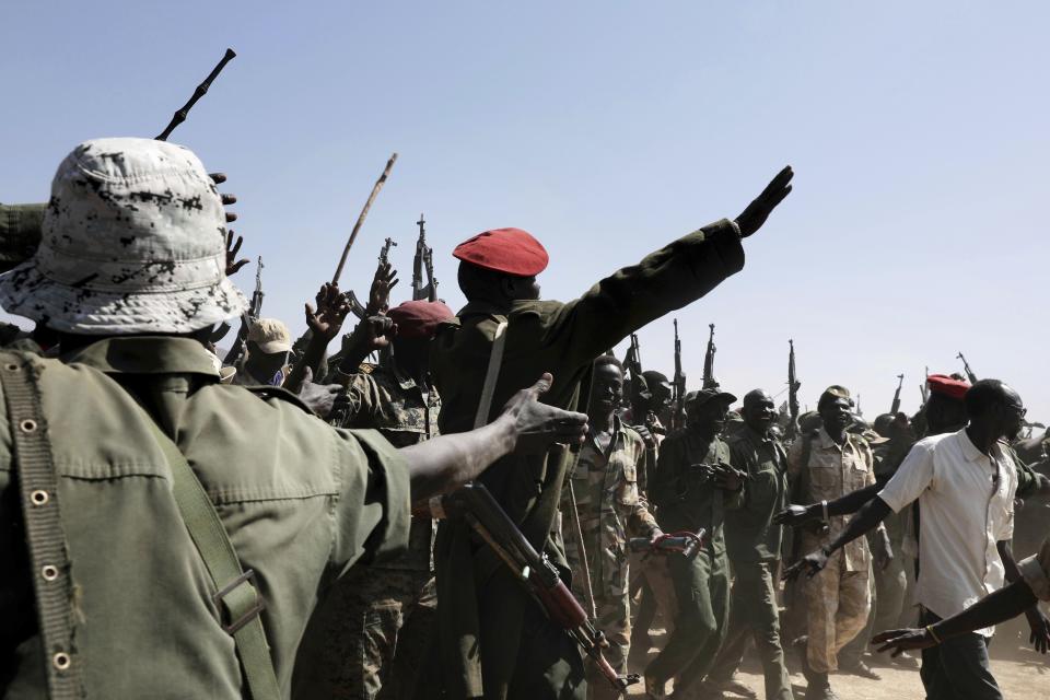 Armed rebels in support of Sudan Liberation Movement-North Leader, Adel-Aziz al-Hilu, chant slogans during a visit organized by The World Food Program (WFP) in the conflict-affected remote town of Kauda, Nuba Mountains, Sudan, Jan. 9, 2020. Sudan’s Prime Minister, Abdalla Hamdok, accompanied by United Nations officials, embarked on a peace mission Thursday to Kauda, a rebel stronghold, in a major step toward government efforts to end the country’s long-running civil conflicts. (AP Photo/Nariman El-Mofty)