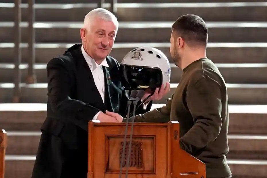 澤倫斯基送給下議院議長霍伊爾（左）一頂空軍飛官頭盔，呼籲英方軍援戰機給烏軍。（翻攝＠MartinGenier推特）