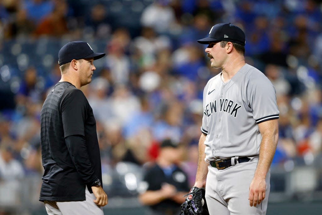 New York Yankees pitcher Carlos Rodon, right, reacts as he meets on the mound with pitching coach Matt Blake, left, during the first inning of a baseball game against the Kansas City Royals in Kansas City, Mo., Friday, Sept. 29, 2023. (AP Photo/Colin E. Braley)