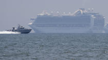 A Philippine military boat passes by the cruise ship Ruby Princess as it is anchored in Manila Bay, Philippines, Thursday, May 7, 2020. The Ruby Princess which is being investigated in Australia for sparking coronavirus infections, has sailed into Philippine waters to bring Filipino crewmen home. (AP Photo/Aaron Favila)