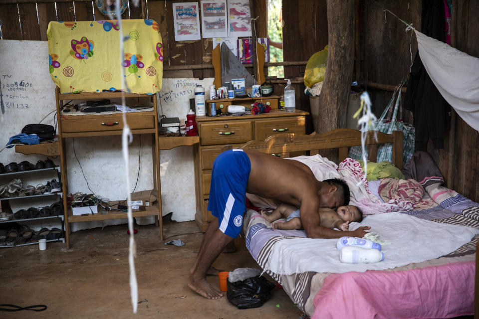 Rolando Cegarra nuzzles his 4-month-old grandson, inside his home in the Caimito Native Community, in Peru's Ucayali region, Monday, Oct. 4, 2020. (AP Photo/Rodrigo Abd)