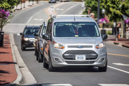 Ford and Virginia Tech Transportation Institute are testing a Ford-designed method for self-driving vehicles to communicate their intent to pedestrians, human drivers and bicyclists in an effort to create a standard visual language people can easily understand. Here, the two white lights on top of the windshield of the Ford Transit Connect move side to side, indicating vehicle is about to yield to a full stop in Arlington, Virginia, U.S. in this handout photo obtained by Reuters September 13, 2017. Ford Motor Company/Handout via Reuters 