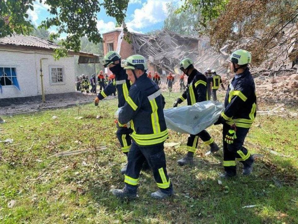 Rescuers carrying a victim’s body out of destroyed school in Romny (Ukrainian State Emergency Servic)