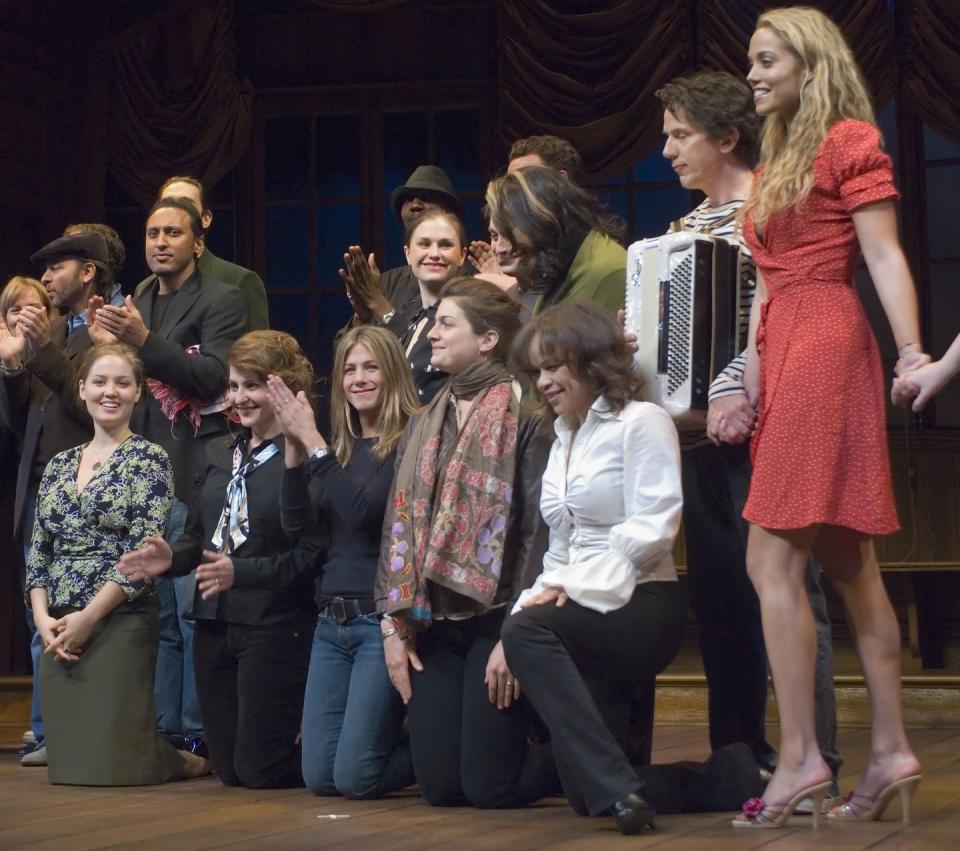 a group of people smiles and poses for photos on a stage