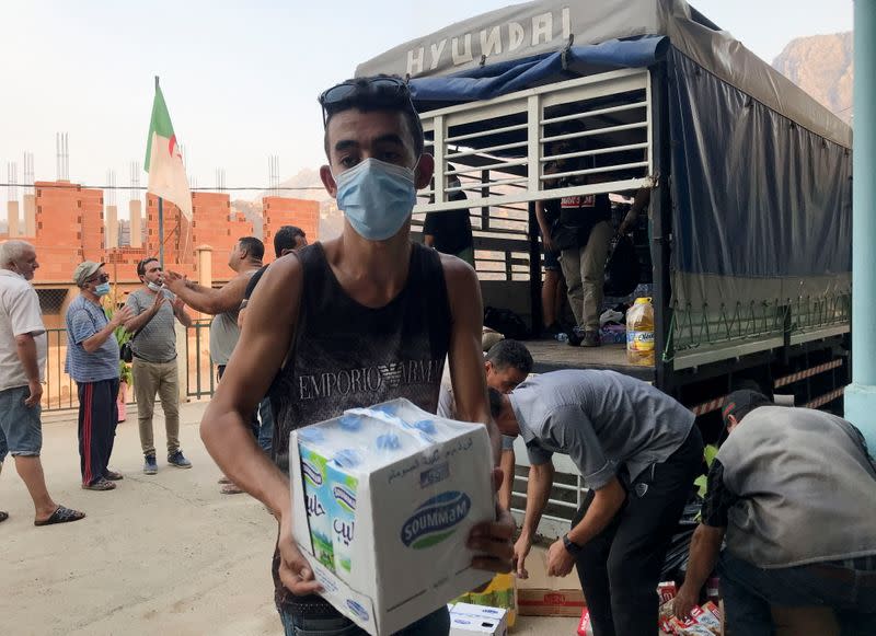 Volunteers unload humanitarian aid to be distributed to people affected by the wildfires in Ait Daoud village