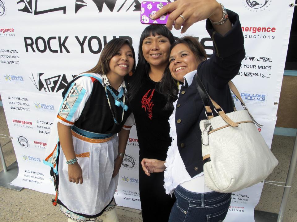 "Rock Your Mocs" creator Jessica "Jaylyn" Atsye of Laguna Pueblo, left, Melissa Sanchez, center, and Antonia Gonzales take a photo during the "Rock Your Mocs" celebration at the Indian Pueblo Cultural Center in Albuquerque, N.M., on Friday, Nov. 15, 2013. The social media campaign has gone global with Native American and indigenous people from as far away as New Zealand participating. (AP Photo/Susan Montoya Bryan)