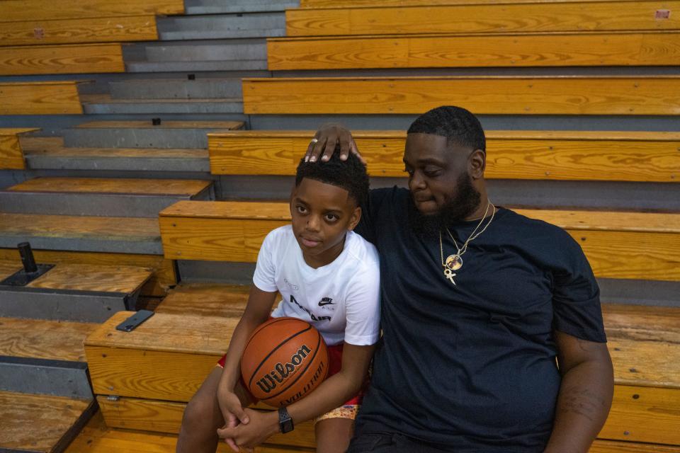 Quinton Collins, 32, rubs his son's hair, Gavin Collins, 11, after practice Thursday, June 9, 2022, at Thrival Indy Academy in Indianapolis. Collins is being celebrated for taking an active role in his son's life, despite not having full custody. He is inspired to be the father figure he didn't have in his life growing up, and he often practices basketball with his son.