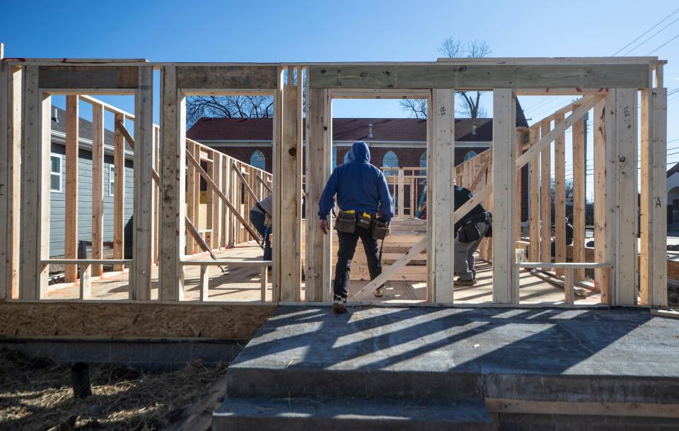 A member of a Habitat for Humanity team enters a home under construction on John Little Street in Louisville's Smoketown neighborhood. Feb. 10, 2022