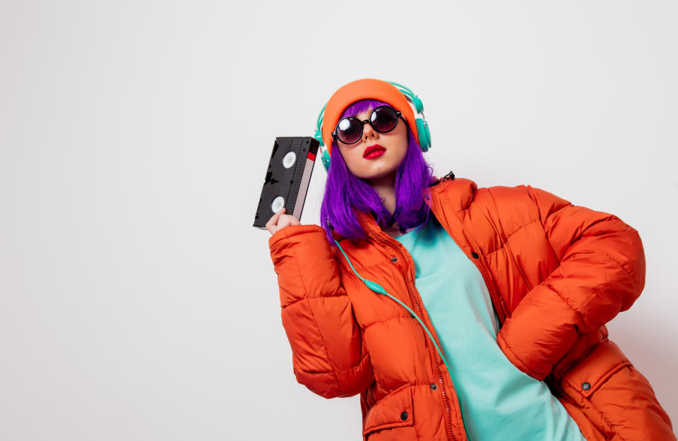 a girl holding a VHS tape and listening to headphones