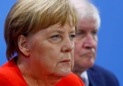 FILE PHOTO: German Chancellor Angela Merkel and Interior Minister Horst Seehofer address a news conference following the so called a housing summit on rising rents in many German cities and a general shortage of affordable housing in Berlin, Germany September 21, 2018. REUTERS/Fabrizio Bensch/File Photo