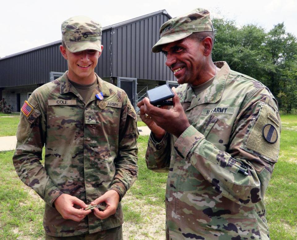 Gen. Gary Brito, commander of the Army’s Training and Doctrine Command, right, and Pvt. Matthew Cole, left, speak with Cole’s father after a ceremony Tuesday at Fort Moore where Pvt. Cole was presented with the Soldier’s Medal for his heroic actions that saved a 3-year-old girl and her father from the rising Chattahoochee River while he was off duty May 26 in Columbus. 08/08/2023